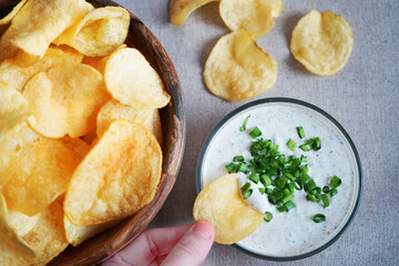 Potato chips with sauce with herbs on a gray background