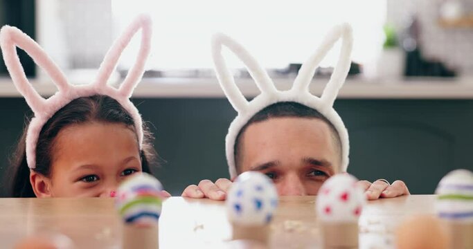 Child, father and easter with eggs, happy or thinking at table for game, festive holiday or celebration. Dad, kid and bunny ears for rabbit costume, ideas or playful for love, bonding and family home