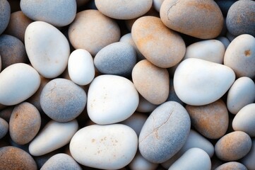 Fototapeta na wymiar Smooth pebbles of various earthy tones closely packed together.
