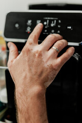 Obraz premium Close up of a human hand with spots of vitiligo disease operating coffee machine