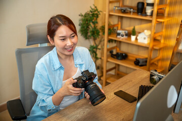 Naklejka premium Young photographer working on her photos at her home office