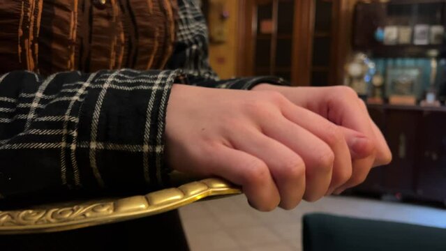Vintage old cafe waitress holding a tray with hands. Dark clothes interior close-up of service staff hands concept of helpfulness in the old memories of the aristocracy.