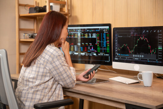 Young woman doing cryptocurrency business trading on her computer at home at nigh
