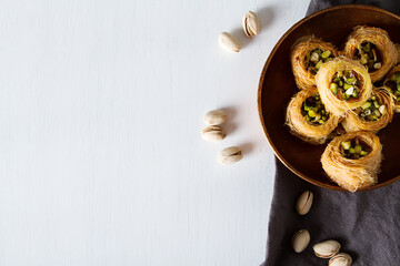 Traditional arabic dessert baklava with pistachios. White background - obrazy, fototapety, plakaty