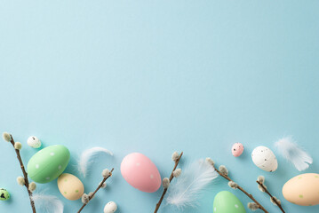 Cheerful Easter tableau: top view of bright eggs, feathers, fuzzy pussy willow on a pastel blue surface. Perfect for your text or advertisement
