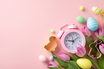 Dive into Easter preparations with top-view arrangement. Alarm clock heralds spring season, encircled by eggs, amusing-shaped cook cutters, tulips on light pink setting. Perfect space for holiday text - obrazy, fototapety, plakaty