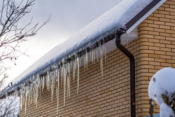roof with snow and icicles hanging from it.