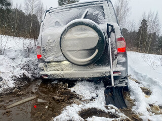 A 4x4 SUV stuck in mud and snow. Problems of car ownership in winter. The concept of adventure...