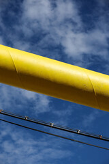 Big yellow gas pipeline isolated against blue sky