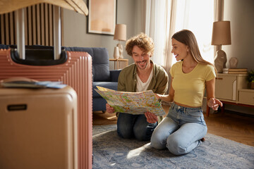 Preparation for vacation concept with happy spouses searching travel rout in map - obrazy, fototapety, plakaty
