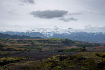 Volcano Eyjafjallajökull with snow and green moss on hills on Icelandic highlands at Landmannalaugar, Iceland. Famous Laugavegur hiking trail with dramatic sky.