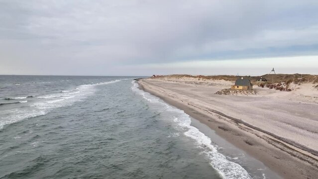 Aerial footage from North Sea coastal landscapes, rhythmic waves near Skagen. Dune landscape with view to the village of Gammel Skagen. Footage of house at the beach Fellen near Gammel Skagen.