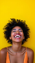 Portrait of a cheerful black woman in front of a vibrant yellow background, happy and joyful expression