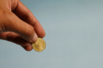 Close up hand holding 50 cent coin Malaysia. Charity concept.