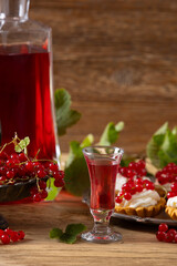 Delicious homemade currant liqueur. Served in a glass and carafe. Served with currant cake.