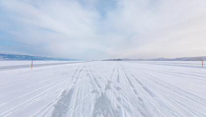 Beautiful winter landscape with car tire tracks (trail) in fresh snow - Baikal Lake, Siberia