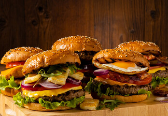 Set of beef and poultry burgers with fried egg, bacon, and grilled halloumi cheese.