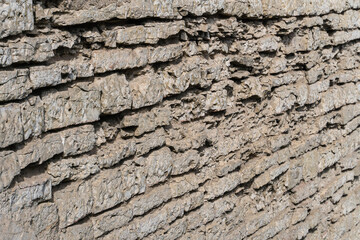 Fototapeta premium The wall of an old fortress made of pieces of natural stone as a background.