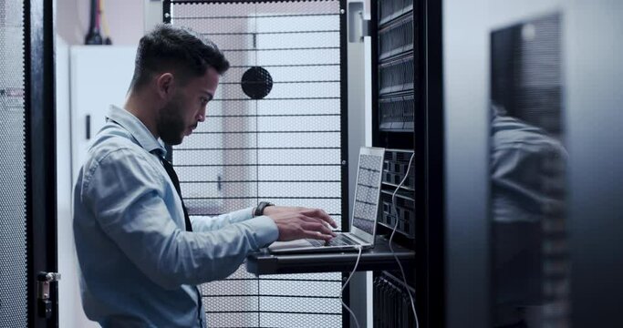 IT, technician and man with computer in server room programming code to repair error or fail in datacenter. Engineer, coding and working on laptop with mistake, glitch or risk in cybersecurity