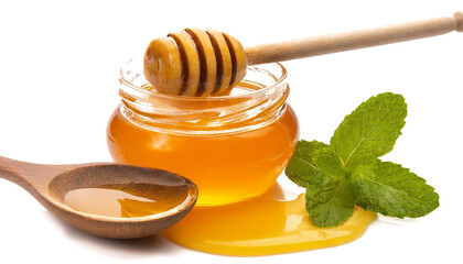 jar of honey with wooden spoon on white background