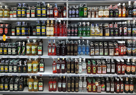 Kyiv, Ukraine - 4 September, 2023: Inside the Auchan supermarket. Showcase with elixir and balsam alcohol in assortment.