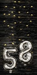 Silver foil balloon number 58 on a background of black tinsel with gold confetti. Birthday card, inscription fifty-eighth. Anniversary event. Vertical banner.