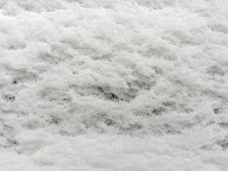 Texture of snow layer on vertical surface in overcast weather