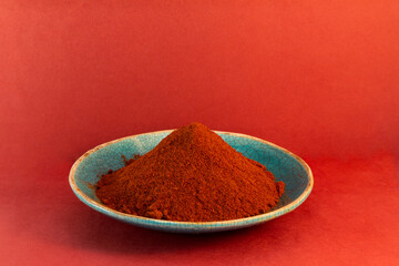 Paprika pepper powder in a rustic ceramic plate 