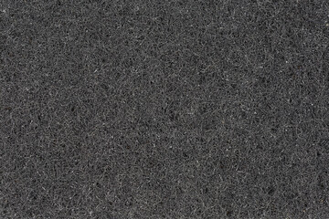 Texture of black hard synthetic material of kitchen cleaning sponge