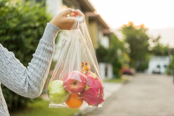 Woman hands carry in a plastic bag fruits on the way home. Hands holding plastic bags for shopping. Set zero waste plastic free concept. Sustainable lifestyle concept.