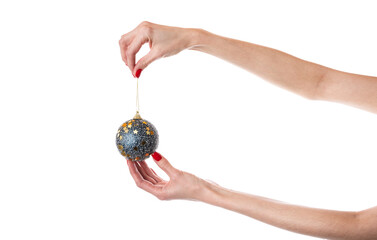 Woman's hand holding decorative Christmas ball over the white wall. Isolated on white background.