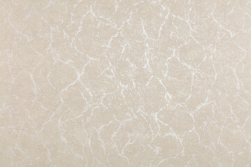 Background of beige evenly textured paper wallpaper with chaotic spots and lines.