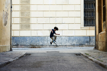 Boy performing skateboarding tricks in the street.