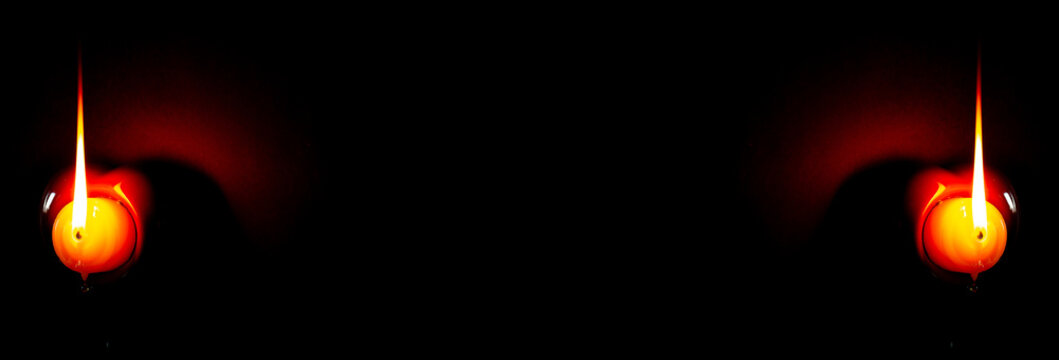 Velhas acesas em uma parede preta. 