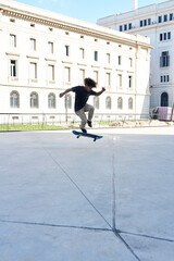 Teenager doing trick on skateboard in the street.