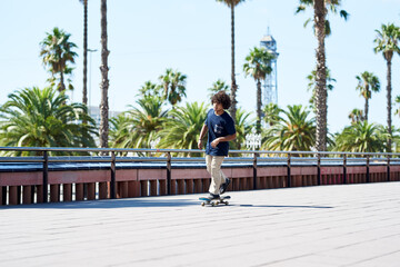 Boy sliding on skate along sidewalk on sunny day.