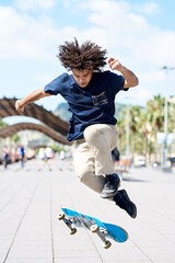 Boy with afro hairstyle performing skateboarding trick.