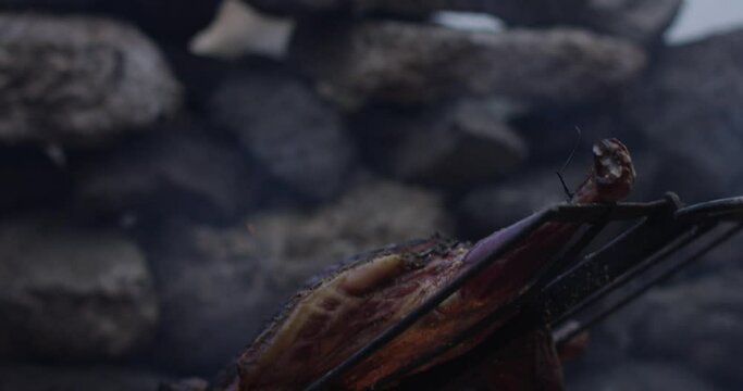 open flames grilling meat on a barbecue
