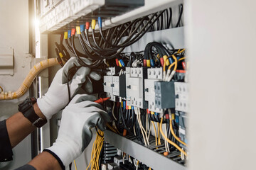 Electrician engineer tests electrical installations and wires on relay protection system.