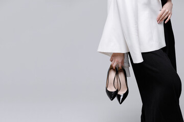 Close-up of woman holding stylish black shoes with copy space