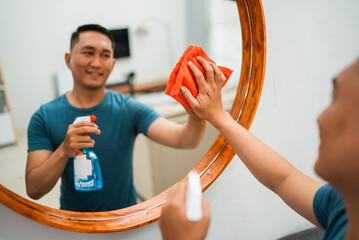 cropped blurred view of man cleans and wipes mirror