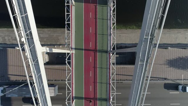 Top view drone Footage of a lonely jogger running on a bridge in Kyiv, Ukraine early in a morning
