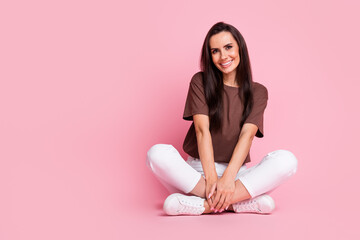 Obraz na płótnie Canvas Full body length photo of charming young woman wear brown t shirt sit floor folded legs near copyspace isolated on pink color background