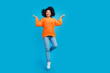 Full body photo of attractive young woman jumping cheerful have fun wear trendy knitwear orange...
