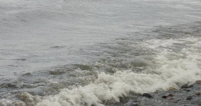waves crashing on the shore of a lake 
