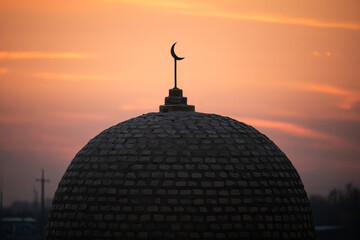 Mosque domes with towers against colorful sunset sky background in evening time