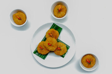 Ketan serundeng pedas, snack made from steamed glutinous rice and sprinkled with spicy seasoned roasted grated coconut, traditional Indonesian dish, on white plate