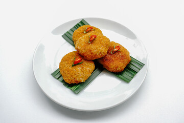 Ketan serundeng pedas, snack made from steamed glutinous rice and sprinkled with spicy seasoned roasted grated coconut, traditional Indonesian dish, on white plate