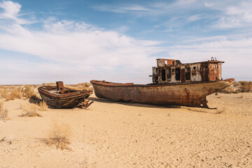 Fototapeta na wymiar rusty ship at the bottom of the former Aral Sea. The dried-up sea in an environmental disaster and climate change in Central Asia. problems of global warming concept,