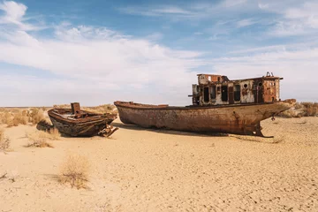 Foto op Canvas rusty ship at the bottom of the former Aral Sea. The dried-up sea in an environmental disaster and climate change in Central Asia. problems of global warming concept, © diy13